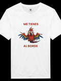 Camiseta unisex blanca de El Cachicamo con estampado de guacamaya expresiva y texto Me tienes al borde en algodón